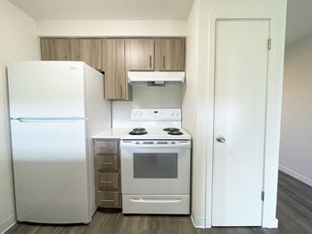 A kitchen with white appliances and a refrigerator and a stove